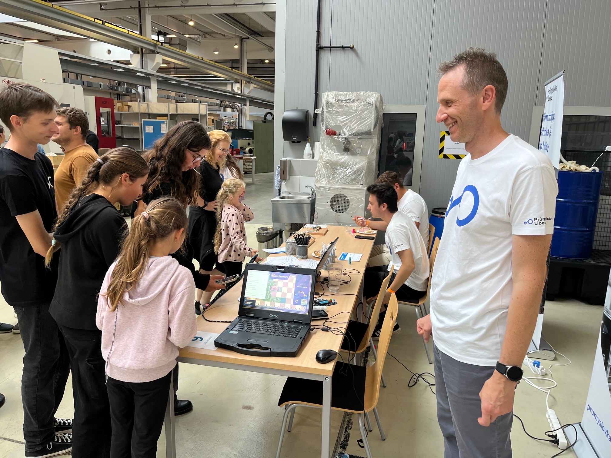 dospělí a děti ve výrobní hale